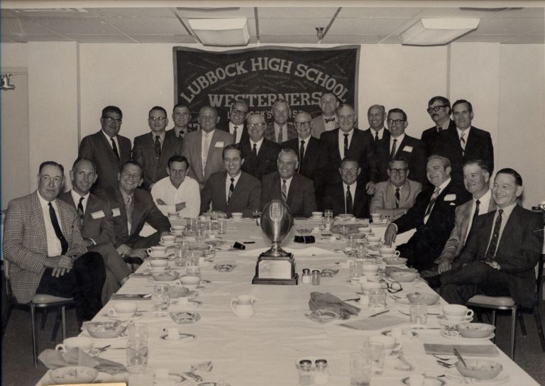 1939 Lubbock State Champion Football Team reunion banquet with a football trophy beneath a Westerners banner