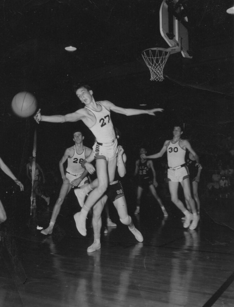 1951 Lubbock State Championship Basketball Team player stretching for a loose ball near the basket in a game photo