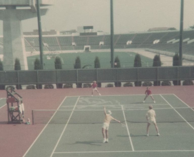 1975 Coronado 4A State Champion Boys Doubles Tennis Team in a doubles match on a stadium court, from a captioned snapshot