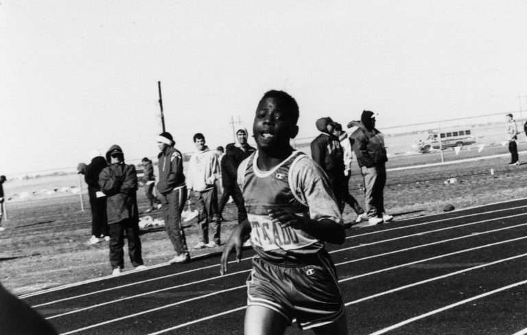 1983 Estacado High School Boys Track and Field State Champions Estacado runner sprinting toward the camera on a track