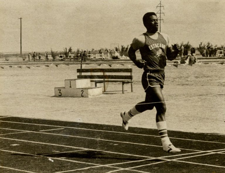 1983 Estacado High School Boys Track and Field State Champions runner in an Estacado jersey at the finish line, sepia print