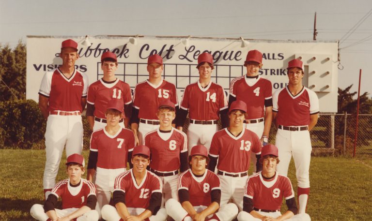 Lubbock Colt League Cardinals in red uniforms posed in front of a Colt League scoreboard, from Bill Dean's photos