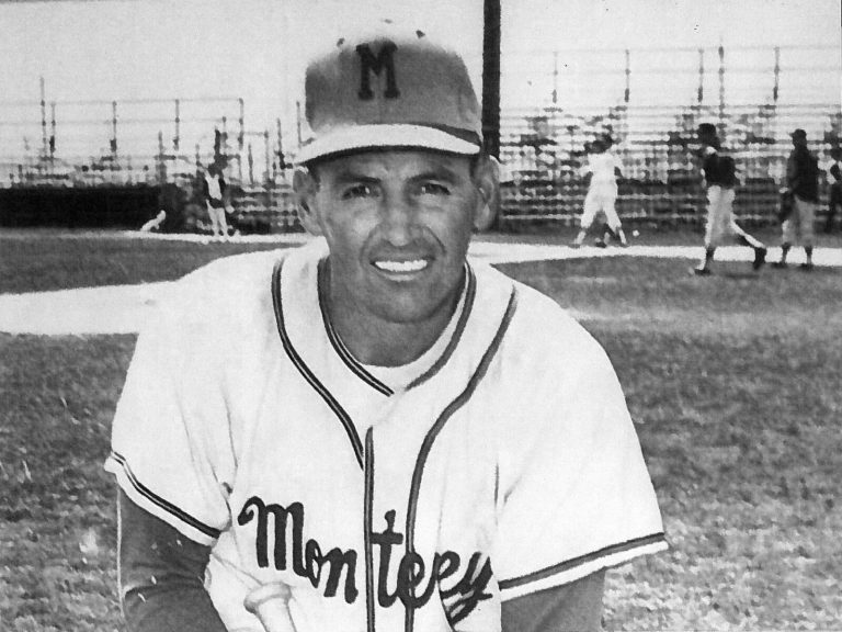 Bobby Moegle smiling in an M cap and Monterey jersey on a baseball field, in a black-and-white photo