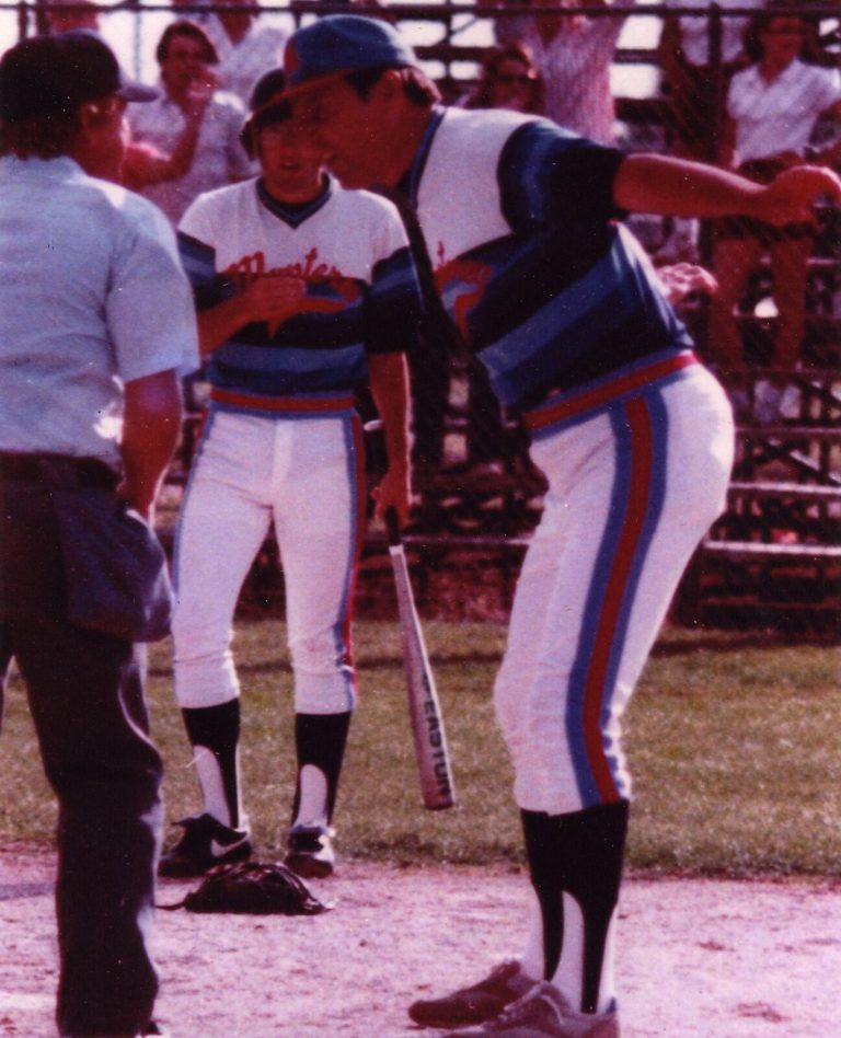 Coach in a striped uniform leaning toward an umpire at home plate, from Bobby Moegle's collection