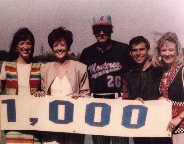 Bobby Moegle holding a 1,000 wins sign with four people