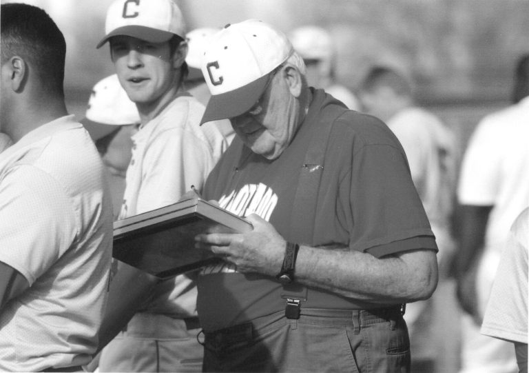 Cal Lowry holding a clipboard among Coronado baseball players, black and white