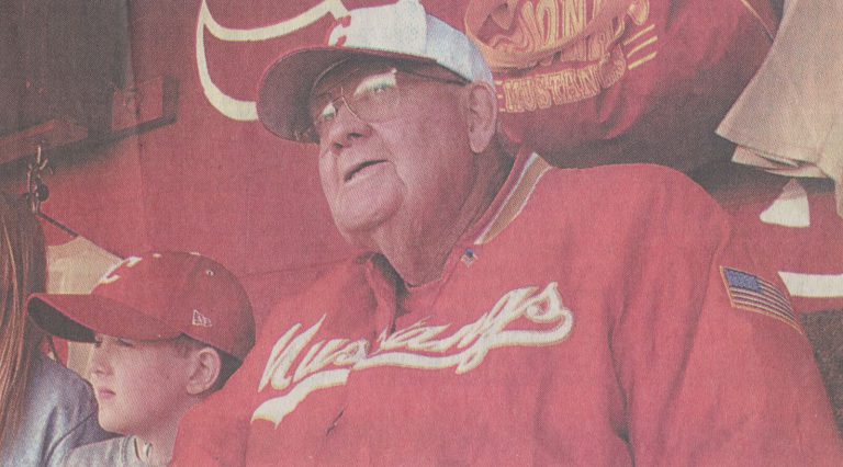 Cal Lowry in a red Mustangs jacket beside a boy in a red cap, from a newspaper feature