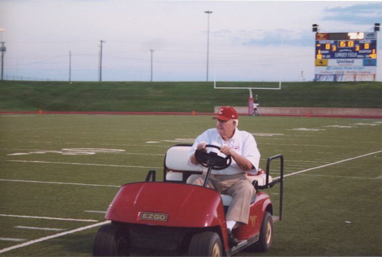 Cal Lowry riding a golf cart on the Coronado football field