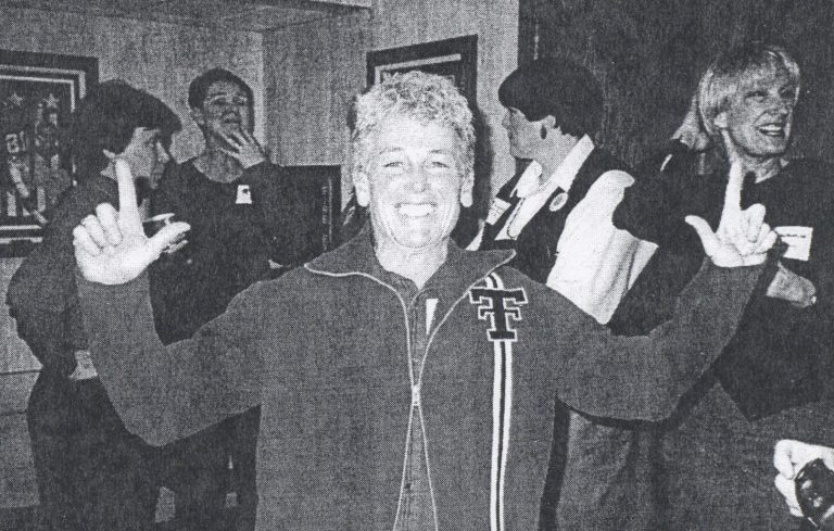 Caylene Caddell smiling in a Texas Tech jacket with both hands raised, from a newspaper photo