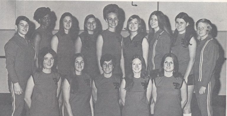 Women's team posed in two rows in matching uniforms, black-and-white team portrait from the Caylene Caddell collection