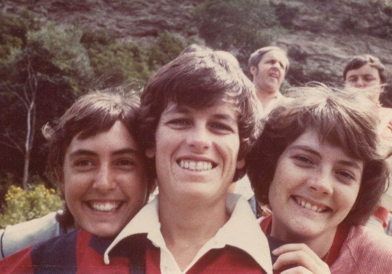 Three smiling young women posing close together in a color snapshot from the Caylene Caddell collection