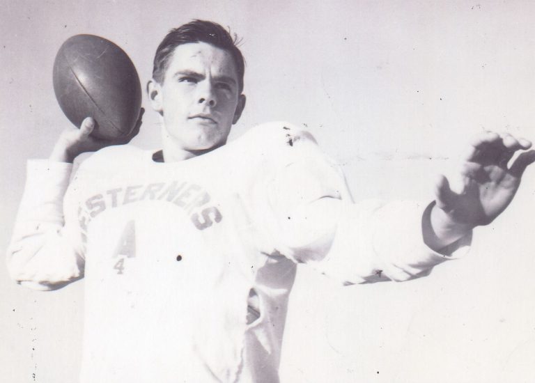 Charles Brewer in a Westerners jersey winding up to pass a football in a black-and-white photo