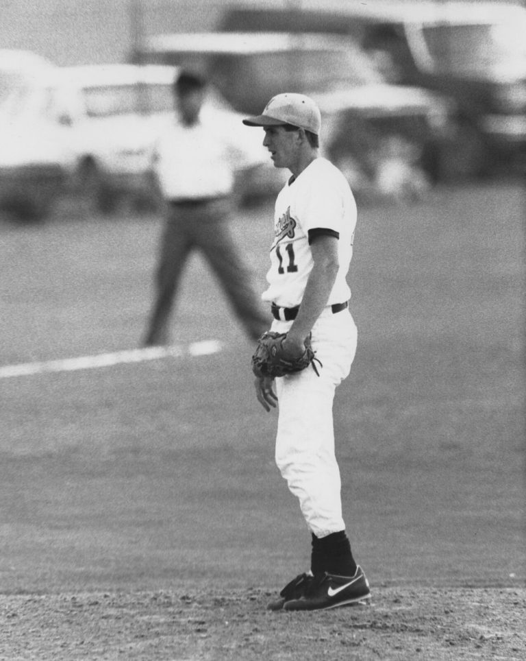 Clint Bryant in a fielding stance with glove ready on a baseball field in a black-and-white game photo