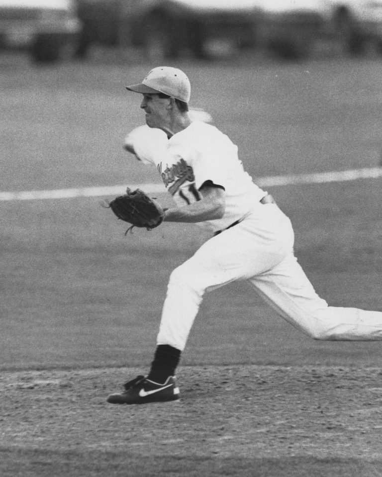 Clint Bryant stepping into a throw with glove extended in a black-and-white game photo
