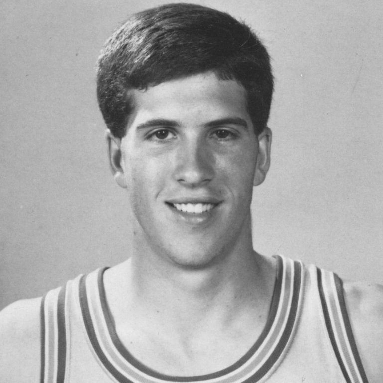 Clint Bryant smiling in a basketball jersey in a black-and-white yearbook portrait