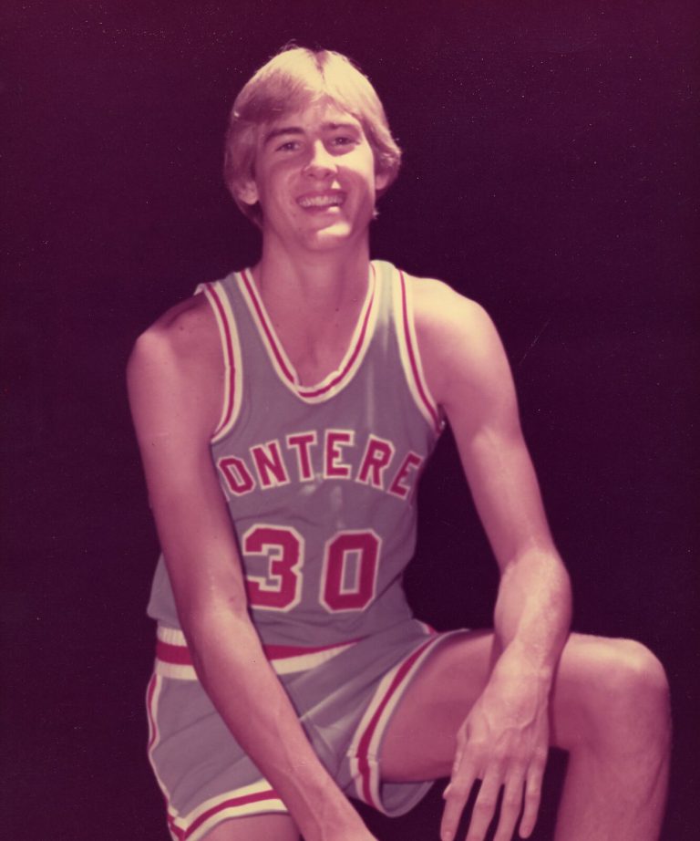 Craig Ehlo smiling in a gray Monterey No. 30 jersey in a vintage color portrait