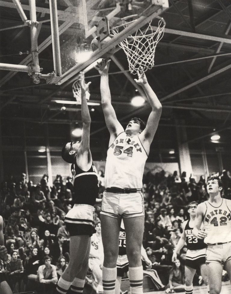 Dan Irons, No. 54, reaching up near the basket for Monterey in a basketball game