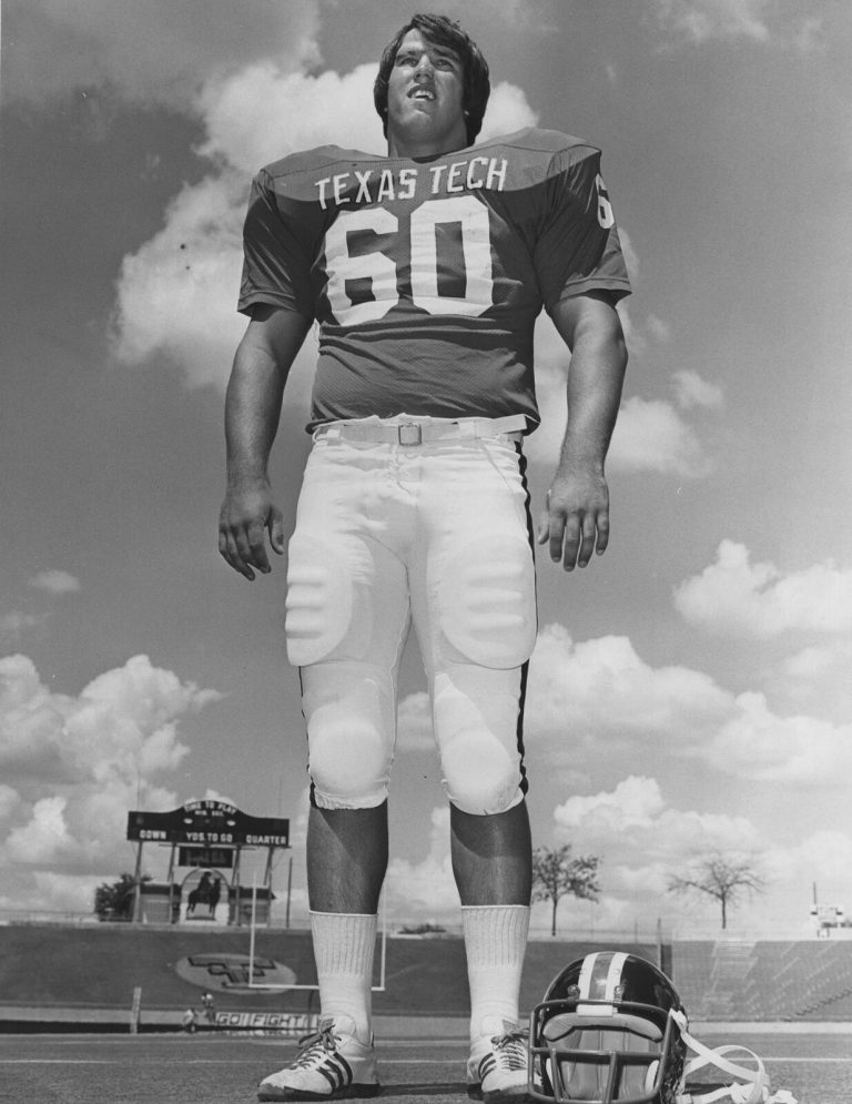 Dan Irons, Texas Tech No. 60, standing on the field with a helmet on the turf, black-and-white