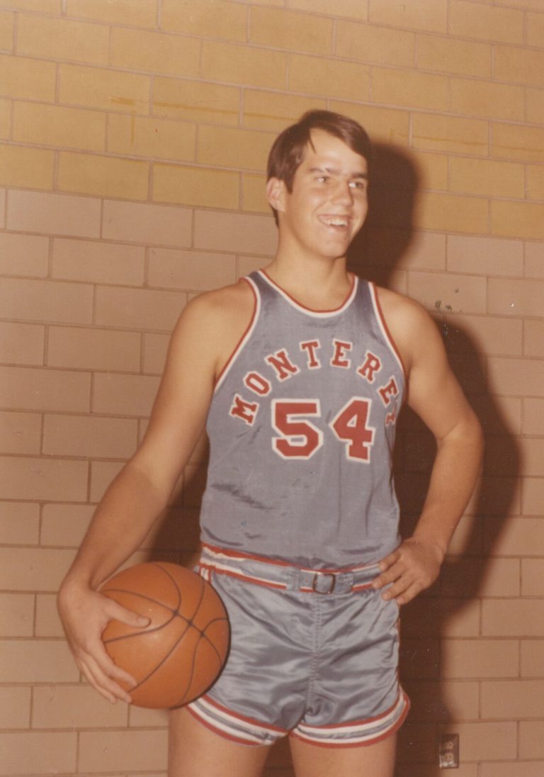 Dan Irons smiling in a Monterey No. 54 basketball uniform, holding a basketball