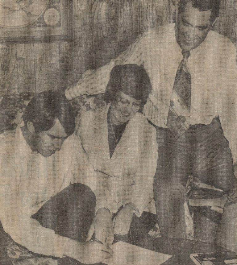 Dan Irons signing a Texas Tech pre-enrollment voucher as parents Mr. and Mrs. Ed Irons look on, from a 1973 newspaper