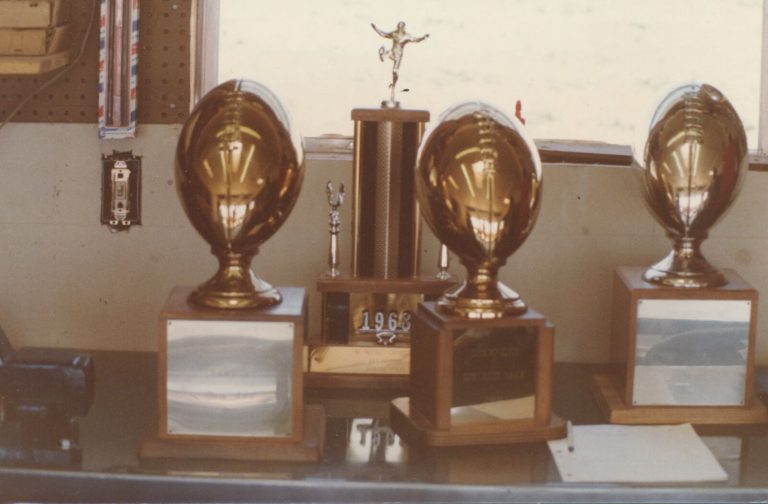 Trophies from David Moody's 1968 Estacado state championship football team displayed on a shelf