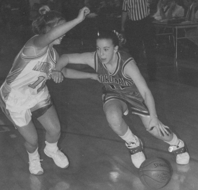 Erika Valek in a Coronado jersey dribbling the ball around a defender in white