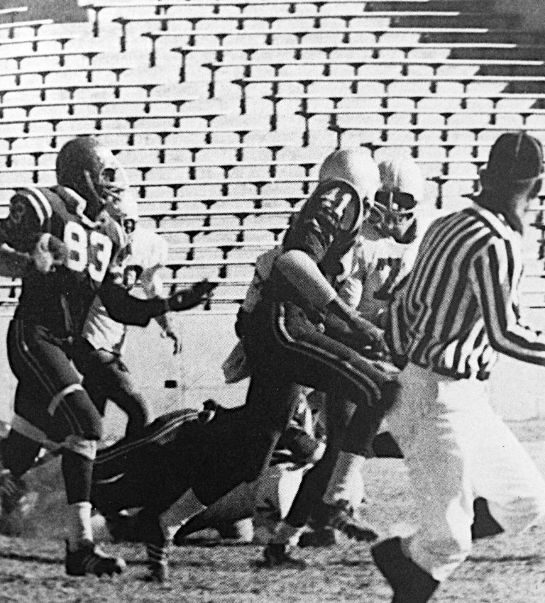 Fred White (83) intercepts a Henderson pass and runs for long yardage