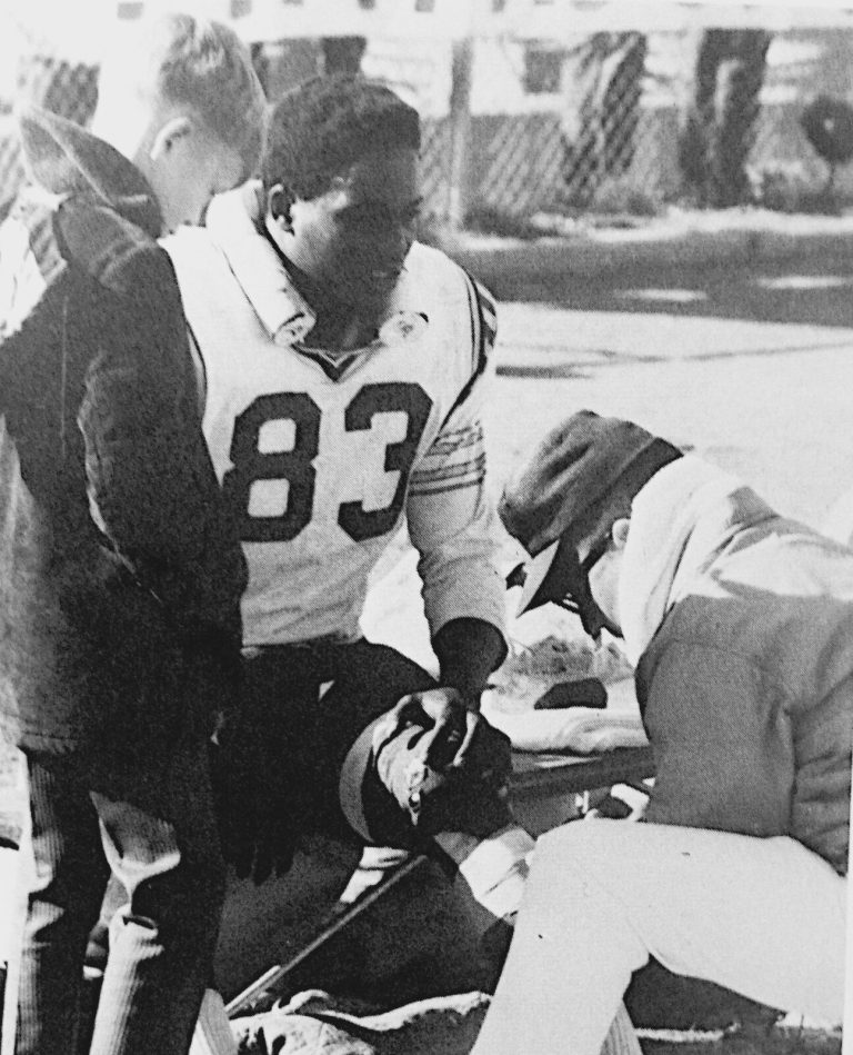 Fred White in a number 83 jersey on the sideline