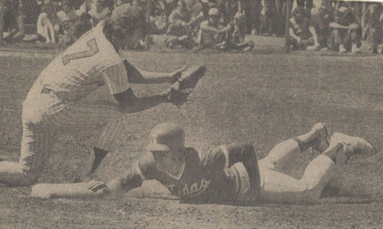 Gary Ashby, Red Raider first baseman, taking a pickoff throw as a Texas runner dives back, from a newspaper clipping