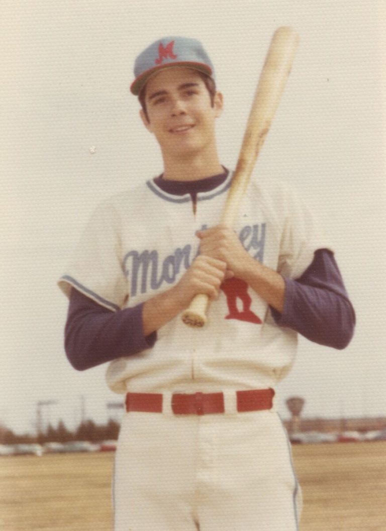 Gary Ashby as a young player in a Monterey baseball jersey and cap, holding a bat, color snapshot