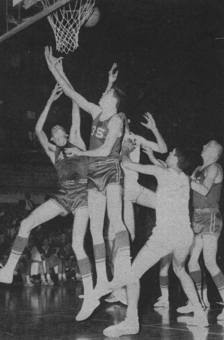 Gerald Myers' Monterey Plainsmen players leaping for a rebound under the basket, black-and-white yearbook photo