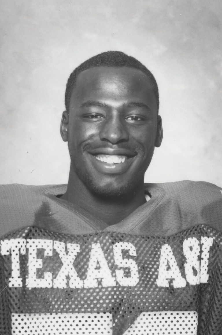 James Collins smiling in a black-and-white portrait wearing a Texas A&I football jersey