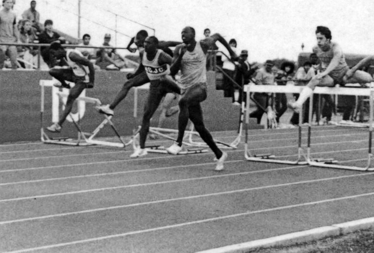 Hurdlers clearing hurdles in a close race, black-and-white photo from the James Collins collection