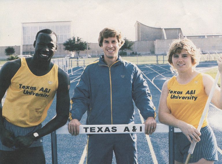 James Collins posing with Texas A&I teammates behind a hurdle on the track