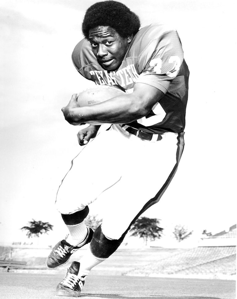 James Mosley in a Texas Tech jersey carrying the football in a black-and-white posed action photo