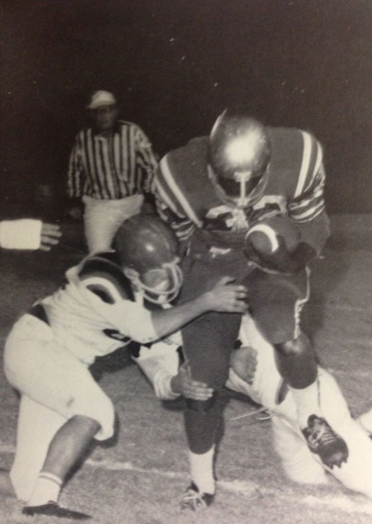 James Mosley carrying the football as a referee looks on behind, black-and-white 1968 game photo