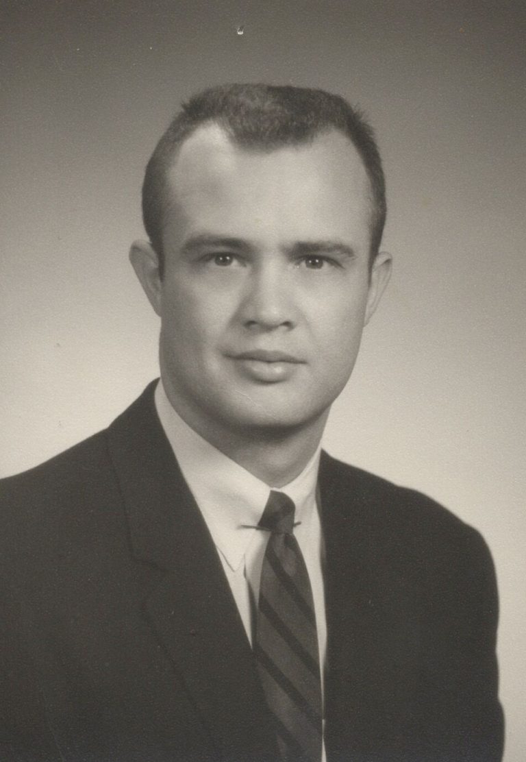James Odom in a dark suit and striped tie in a formal black-and-white portrait