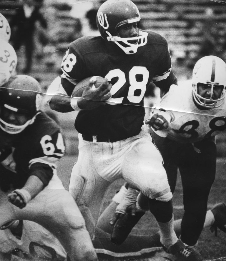 James Ray Jackson, number 28 in an OU helmet, running with the football past defenders