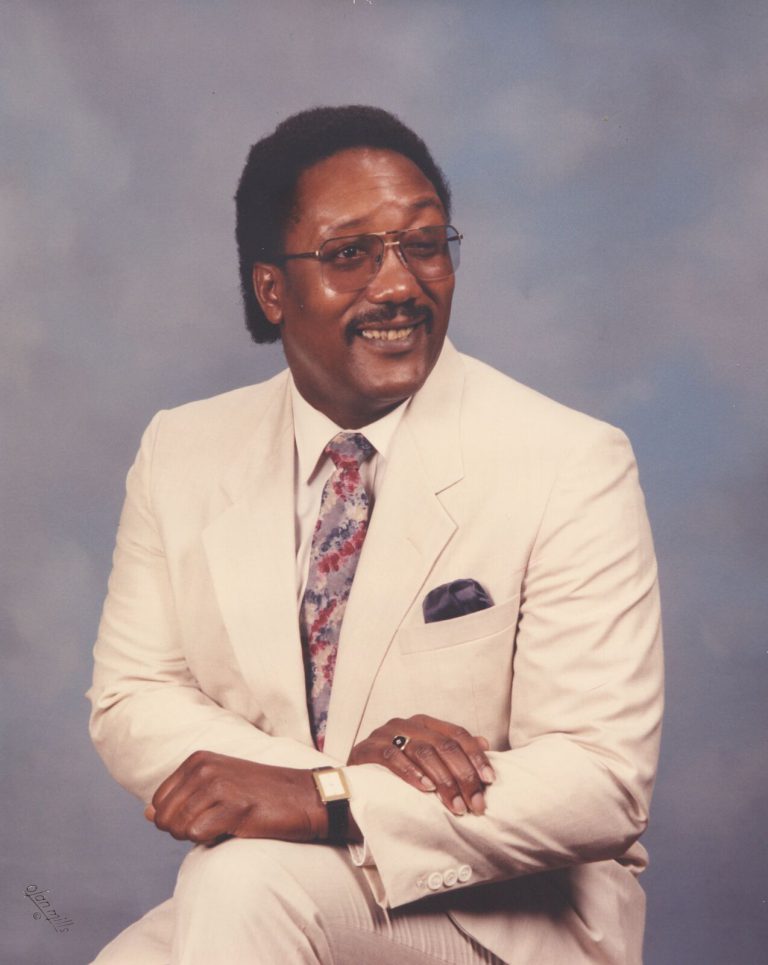 James Ray Jackson in a cream suit and floral tie in a studio portrait