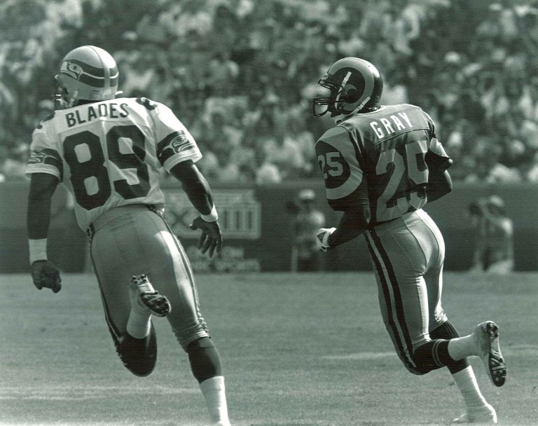 Jerry Gray, No. 25 for the Rams, running downfield beside Seahawks player No. 89 Blades in a black-and-white photo