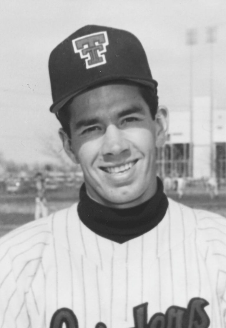 Jerry Haggard smiling in a Texas Tech baseball cap, black-and-white portrait
