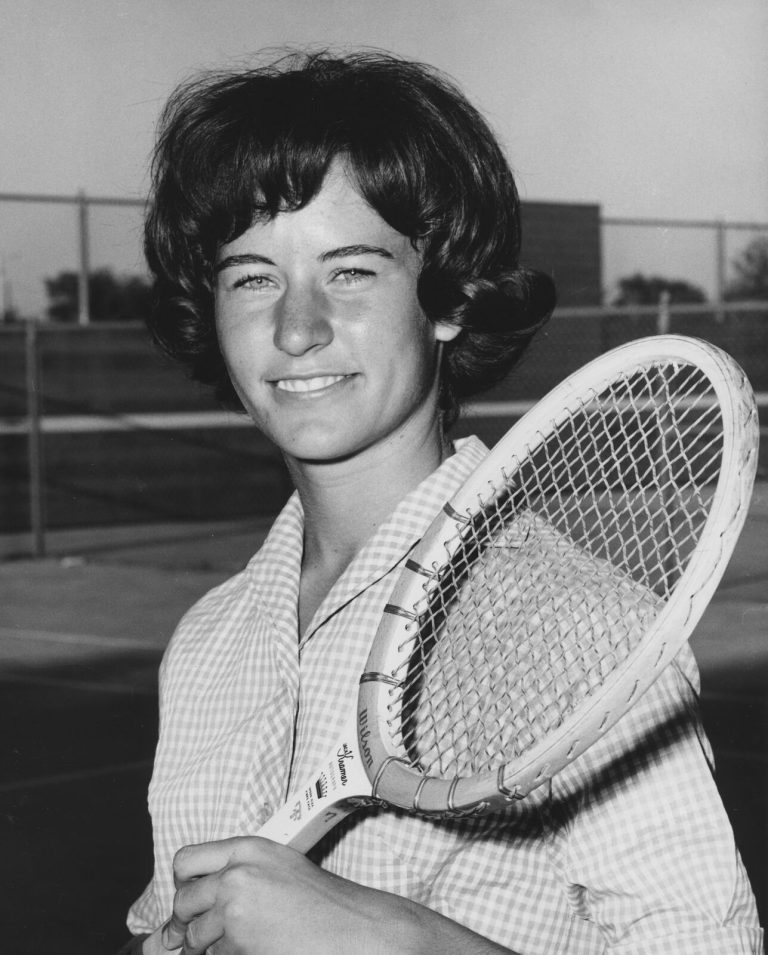 Jill Philbrick Gentry smiling with a tennis racket resting on the shoulder in a black-and-white portrait
