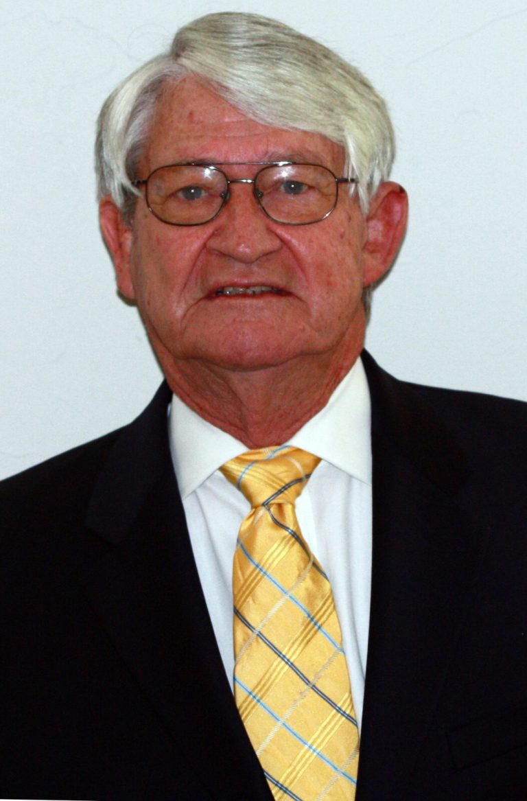 Jimmie Keeling in a black suit and yellow tie, portrait