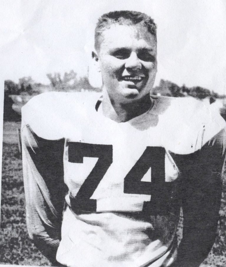Jimmy Gafford, No. 74, smiling in a white football jersey on the field, black-and-white