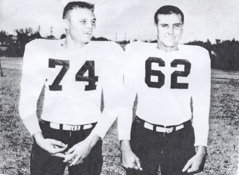 Jimmy Gafford, No. 74, standing beside teammate No. 62 in white football jerseys