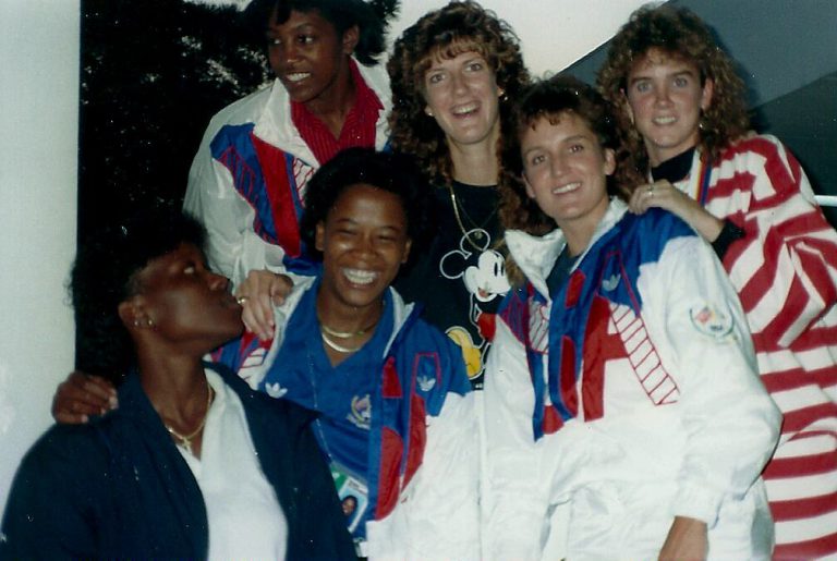 Kamie Ethridge's USA teammates posing together in red, white and blue warm-up jackets