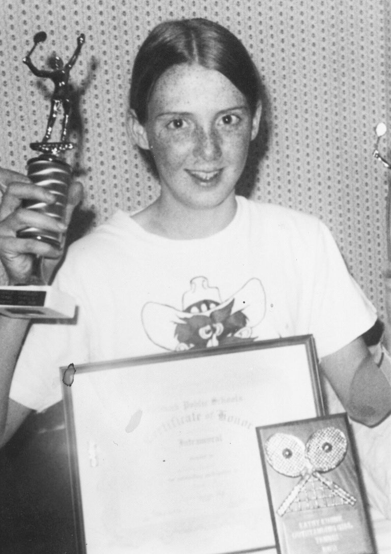 Kathy Kuhne Vick as a young player holding a trophy and a framed certificate, black and white
