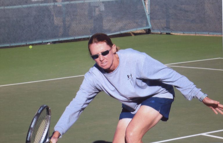Kathy Kuhne Vick lunging for a low shot at a senior tennis tournament