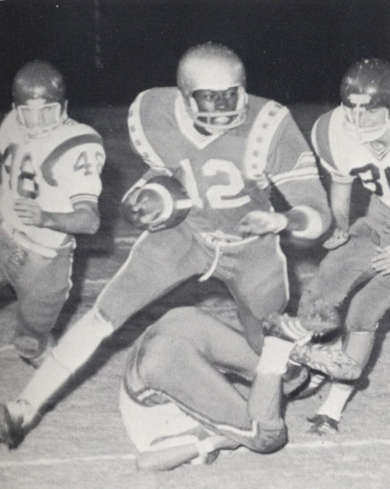 Kenneth Wallace, No. 12, carrying the ball around right end against Plainview, from a yearbook page