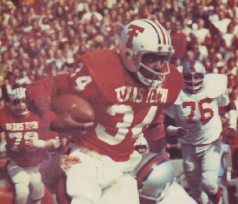 Larry Isaac scoots for yardage in a red Texas Tech number 34 jersey against SMU, from a magazine page